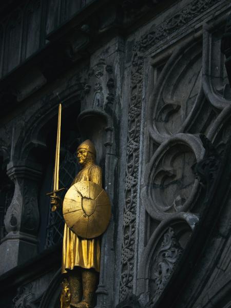 Golden statue of a knight with sword and shield