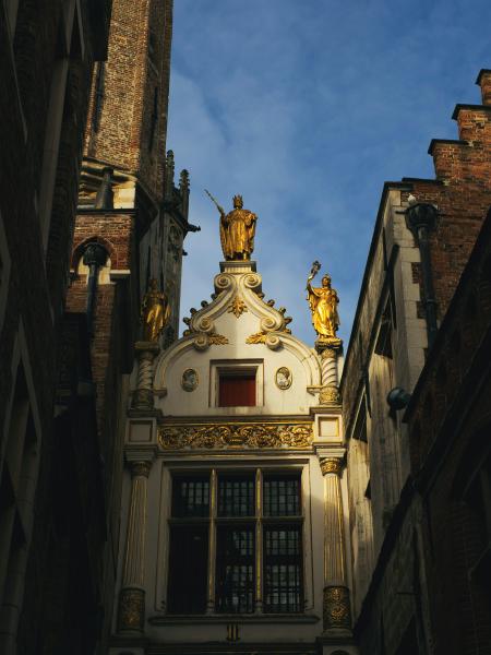 Ornate building facade with golden statues and blue sky