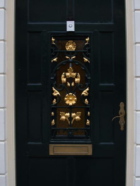 Ornate dark green door with golden floral details