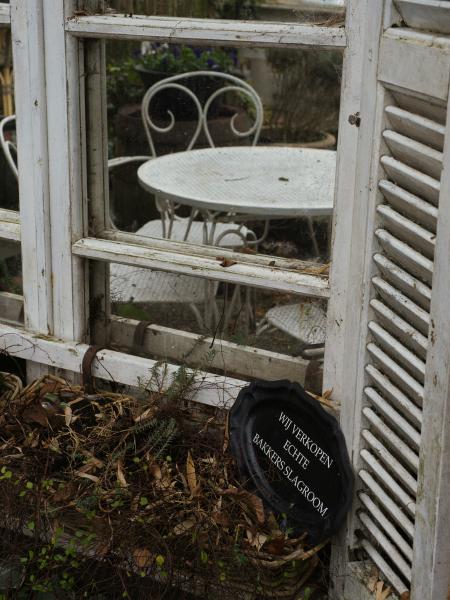 White bistro table and chairs behind glass